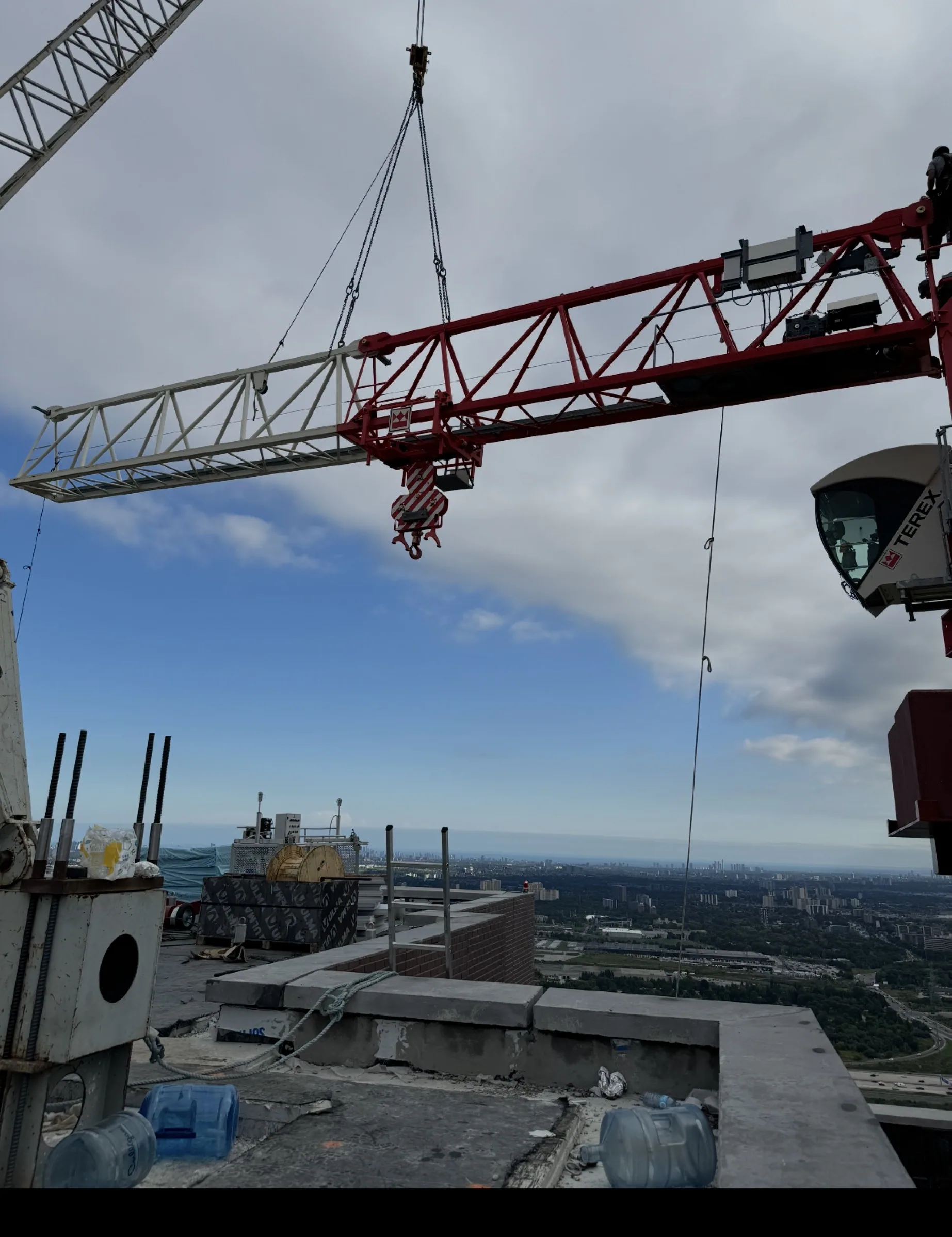 Red derrick crane working from a rooftop above the city