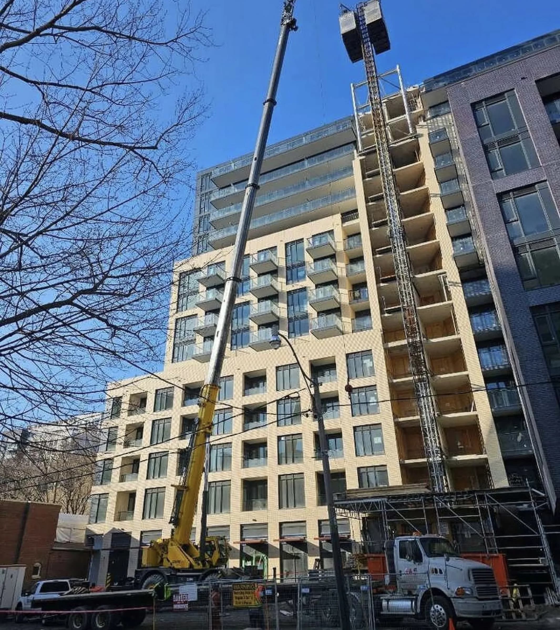 JTM Cranes mobile crane working from the street at a mid-rise residential build