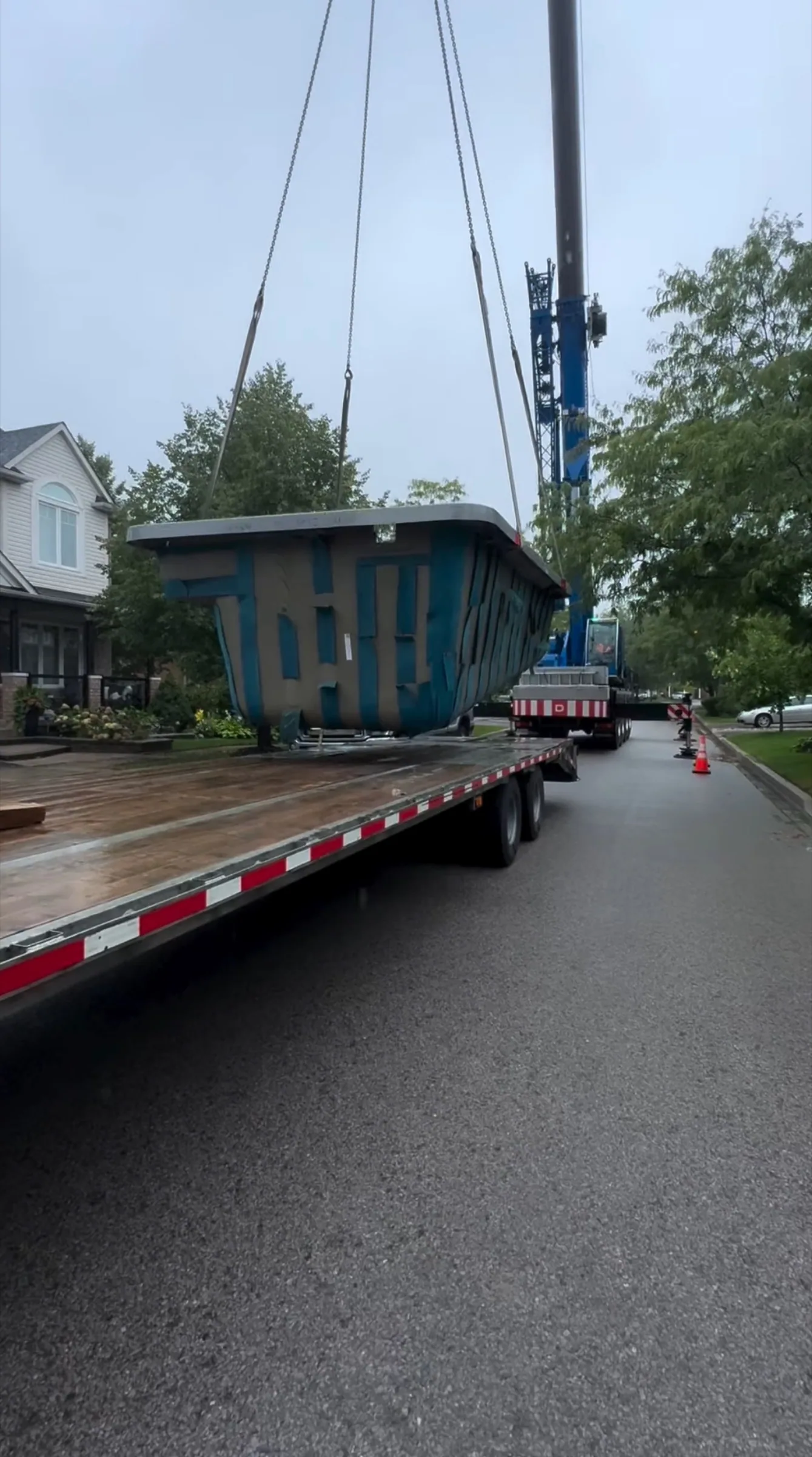 Prefabricated unit being lifted onto a flatbed trailer for hauling